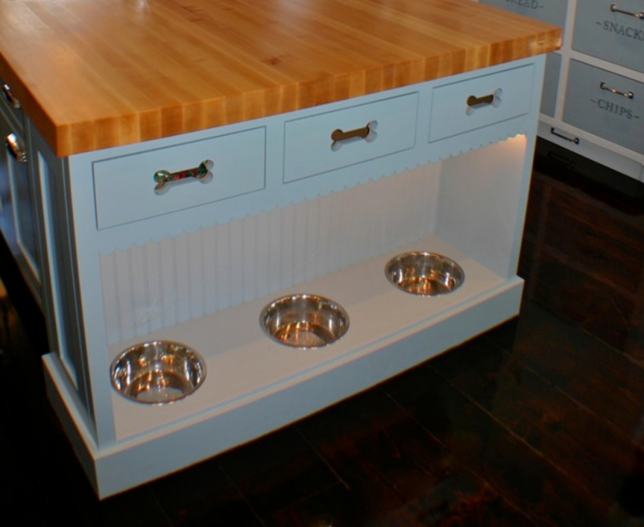 Dog bowls on the end of kitchen Island. 